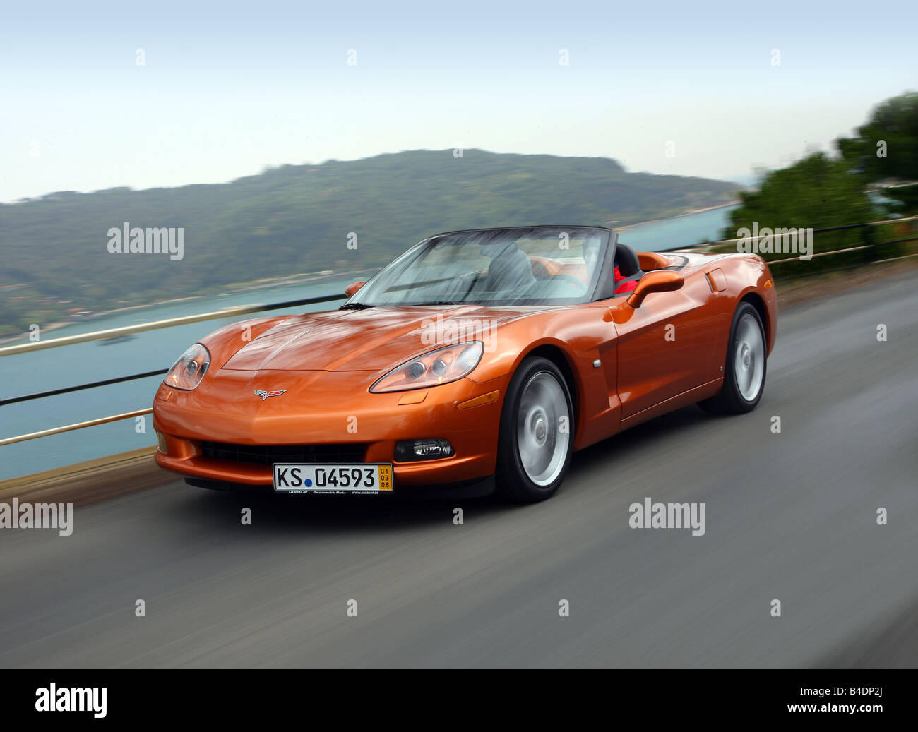 Corvette C6, la rouille rouge-orange, de l'année modèle 2008, la conduite métallique -, diagonale de l'avant, vue frontale, country road, open top Banque D'Images