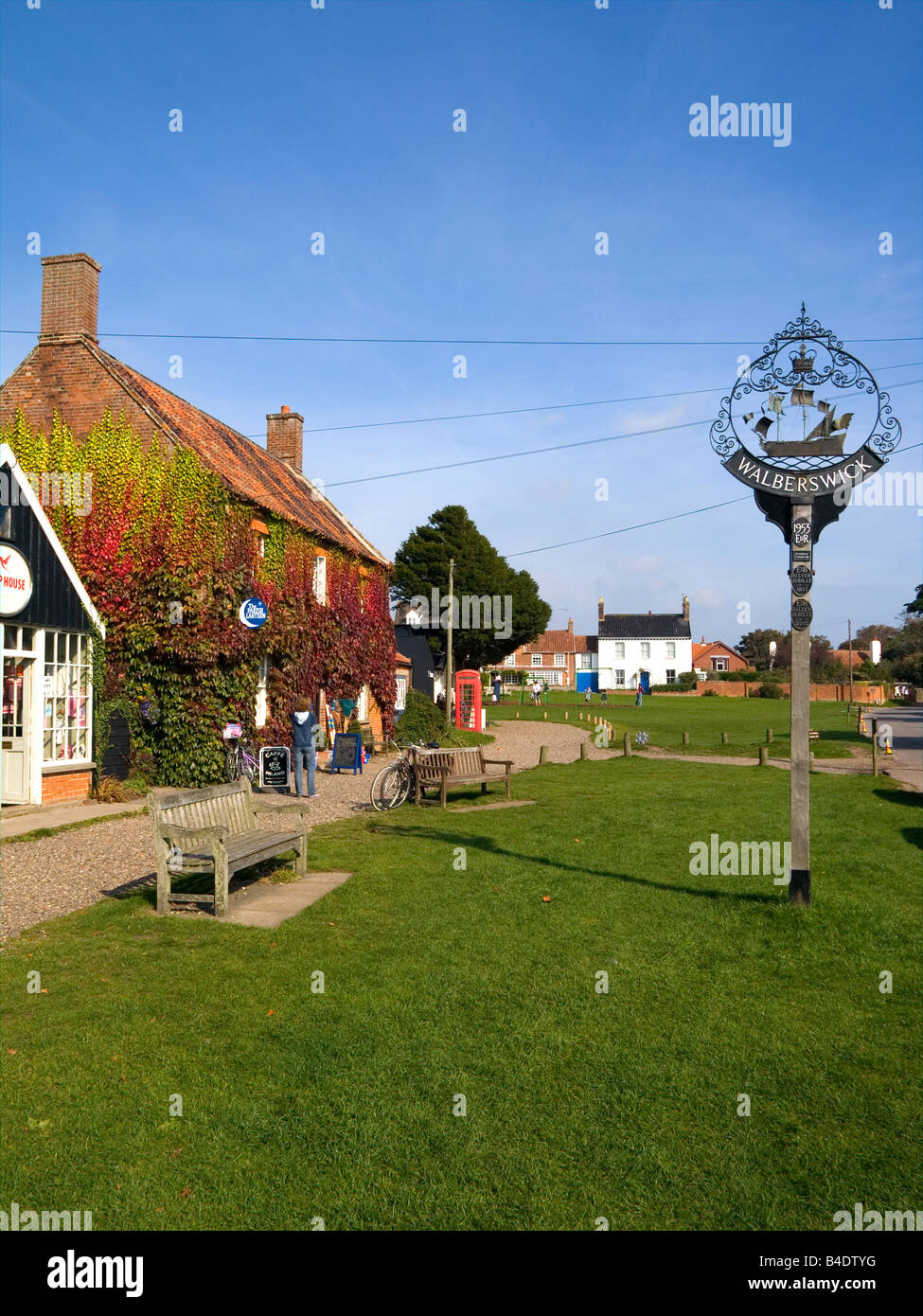 Un nom de signer et de maisons traditionnelles par le village green à Walberswick UK Suffolk Banque D'Images