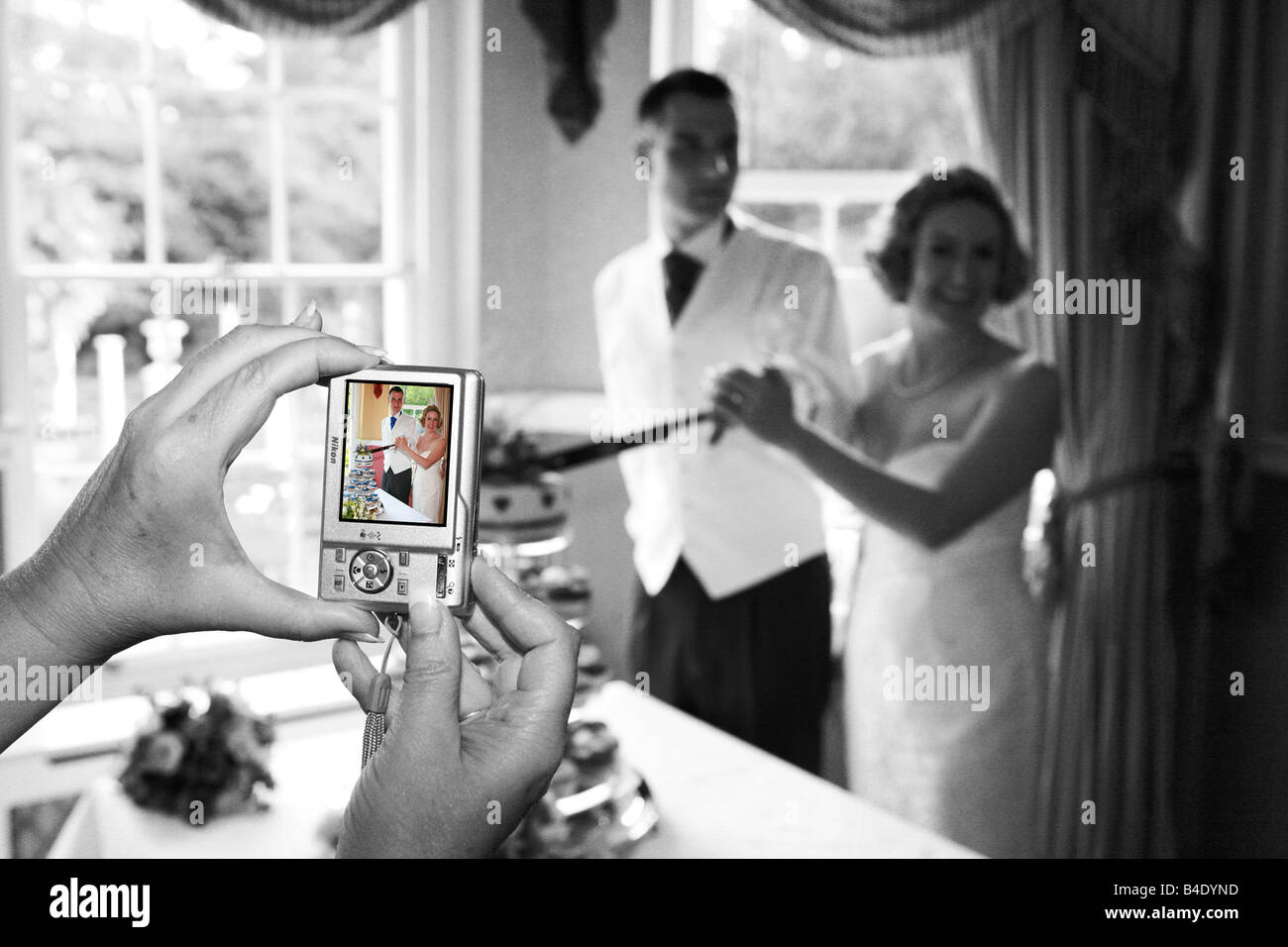 Les mariés couper le gâteau le jour de leur mariage photographié par un appareil photo numérique à l'aide d'image moderne différents inhabituelle Banque D'Images