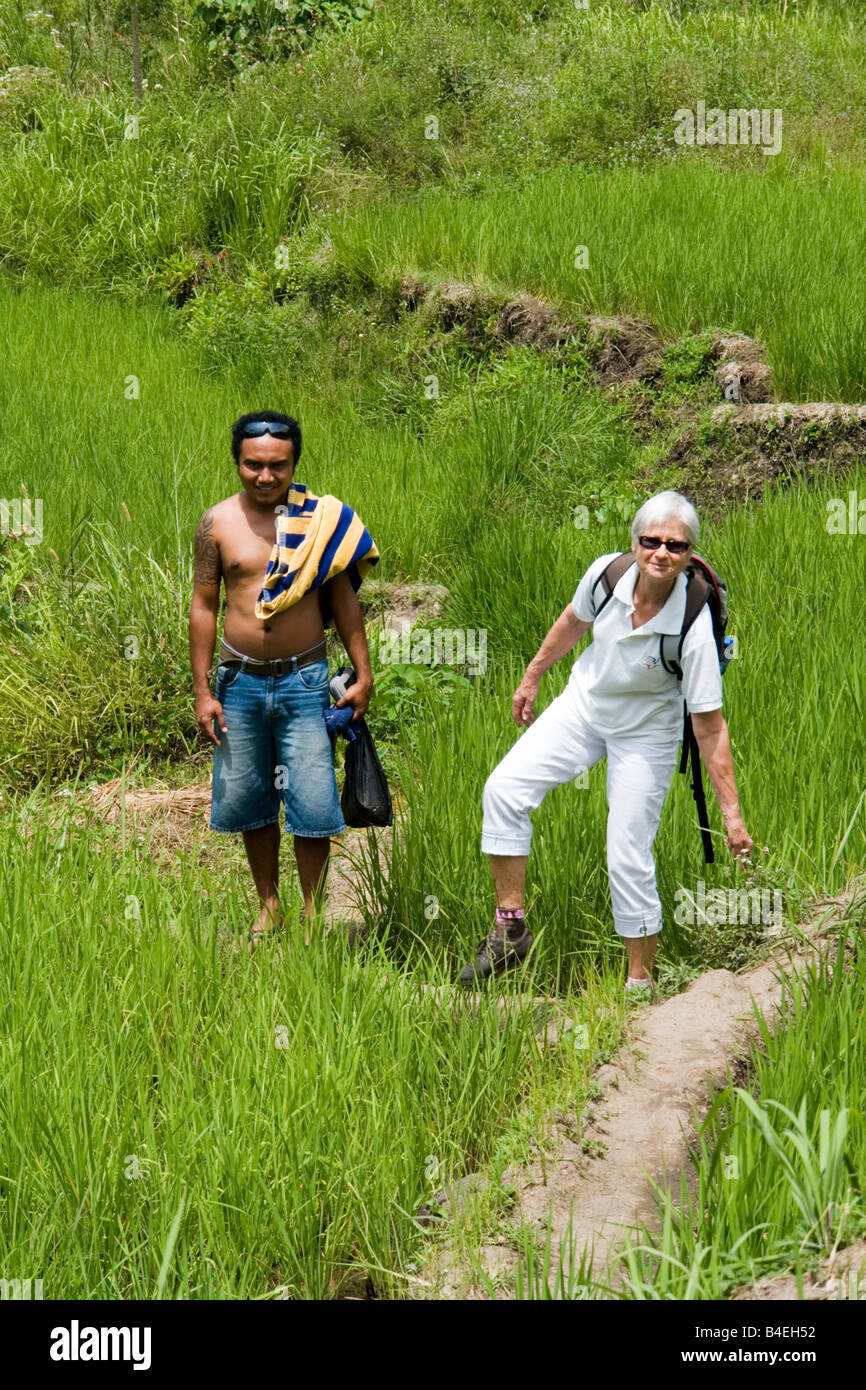 Une dame ayant touristiques tombé dans la boue d'un champ de riz (Moni - Flores). Le faux-pas d'une touriste dans une rizière de Moni. Banque D'Images