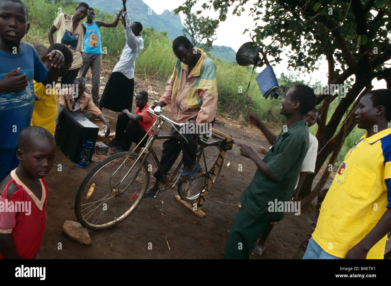 Les villageois à pédales en écoutant la radio dans l'Ouganda. Banque D'Images