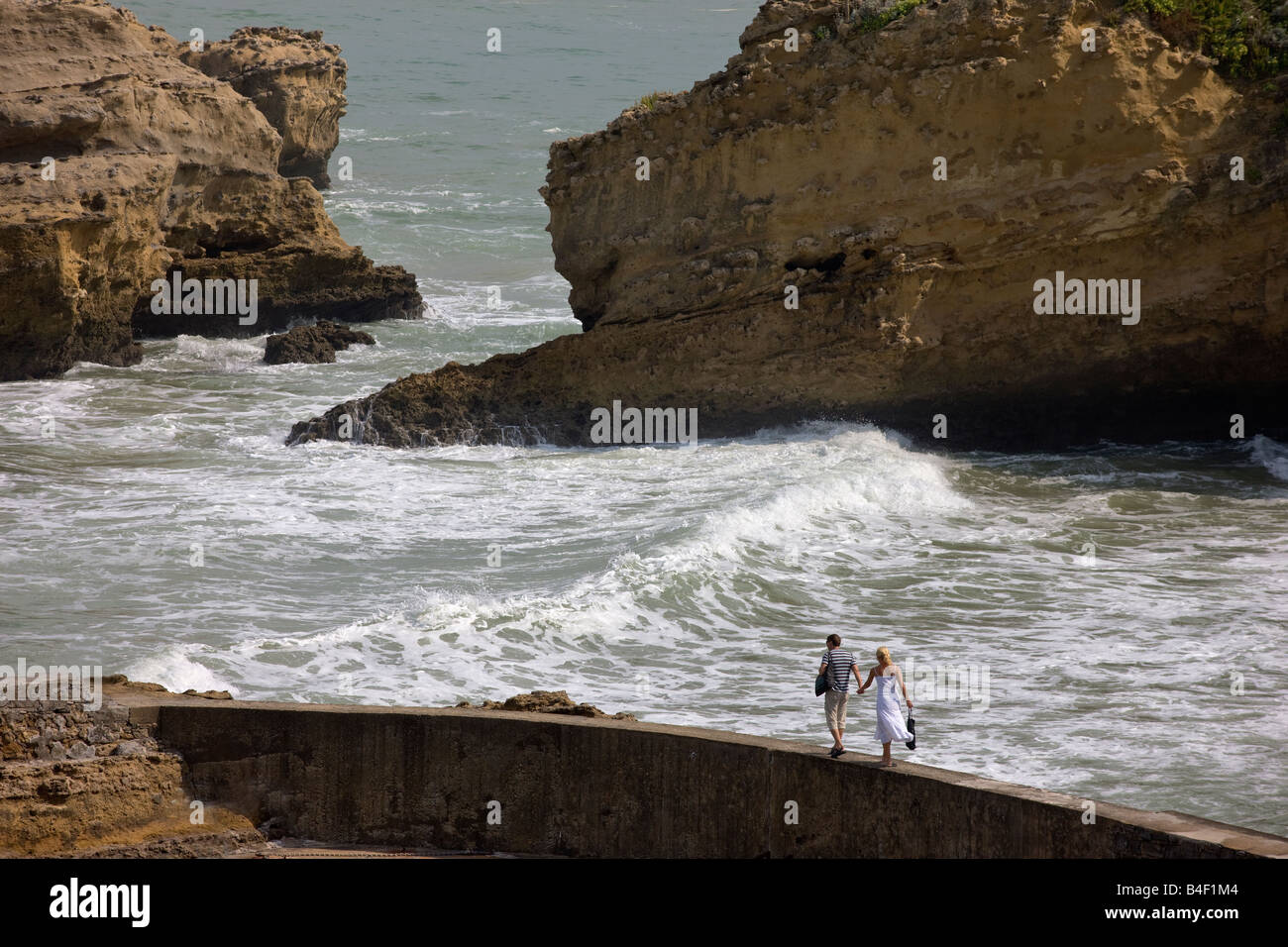 L'homme et la femme sur un mur de la Mer de Biarritz une ville balnéaire dans le sud-ouest de la France sur l'Océan Atlantique Banque D'Images