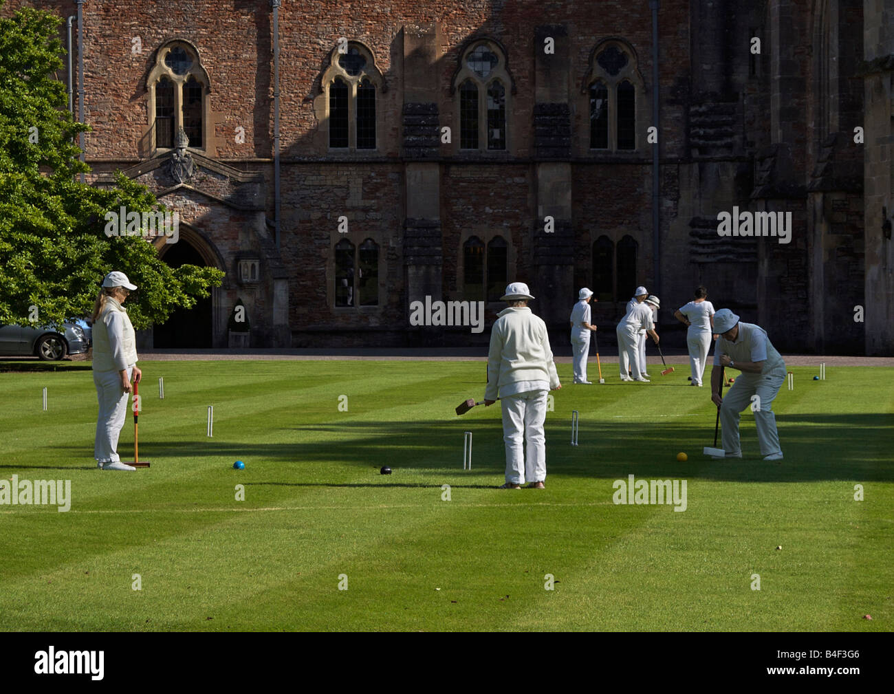 Les gens playing croquet au Bishop's Palace et jardins de la ville de Wells, Somerset, Angleterre Banque D'Images