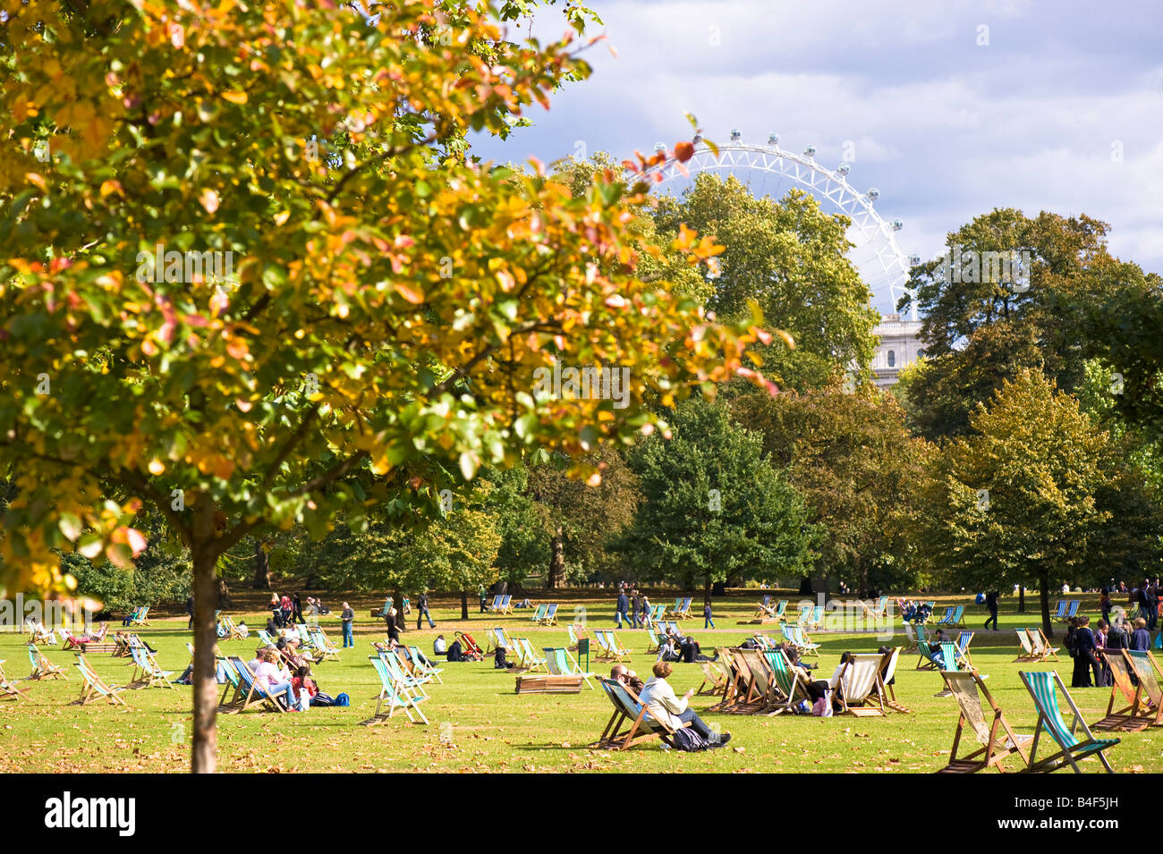 Les gens se détendre sur automne chaud journée à St James's Park London United Kingdom Banque D'Images