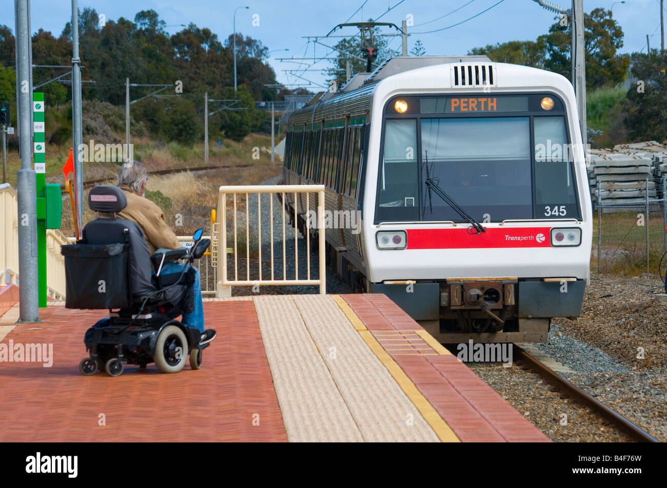 Personne en fauteuil roulant attendant sur le quai pour un train de banlieue à Perth, Australie occidentale Banque D'Images