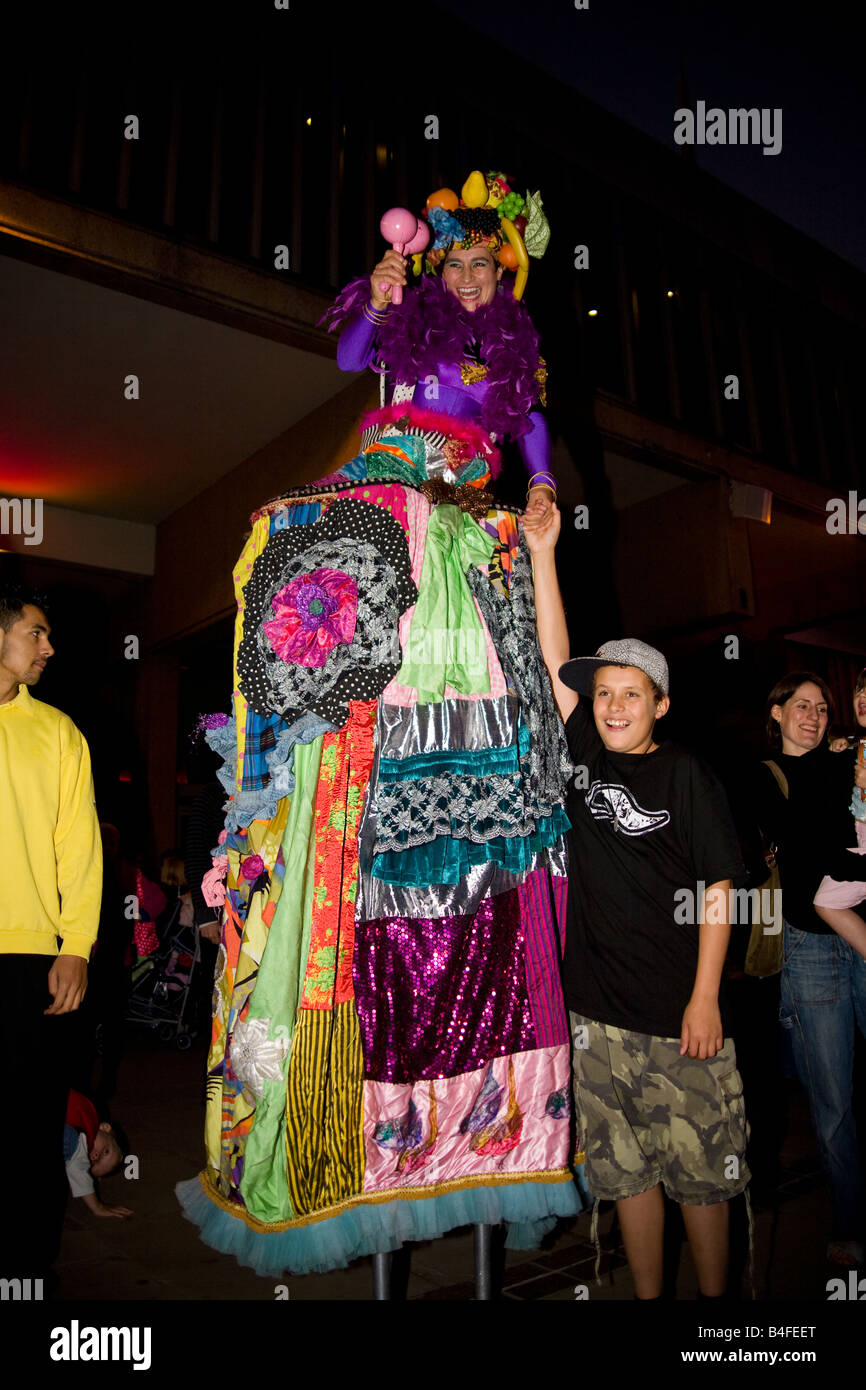 Un artiste de rue carnaval sur pilotis interagit avec la foule. Banque D'Images