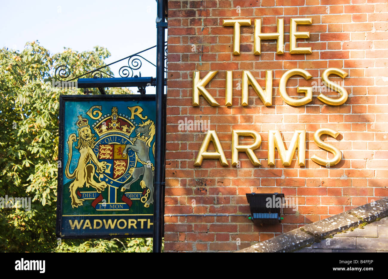 Hanging enseigne de pub et lettres d'or sur le mur de la King's Arms dans tous les Cannings, Wiltshire, Angleterre, Grande-Bretagne, Royaume-Uni Banque D'Images