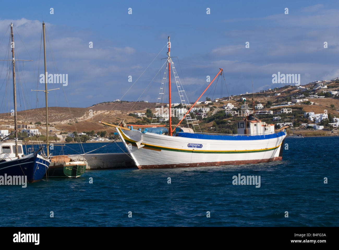 Les yachts et les travailleurs grecs traditionnels Bateau amarré au quai à Parikia Harbour à l'île de Paros Cyclades Grèce Mer Egée Banque D'Images