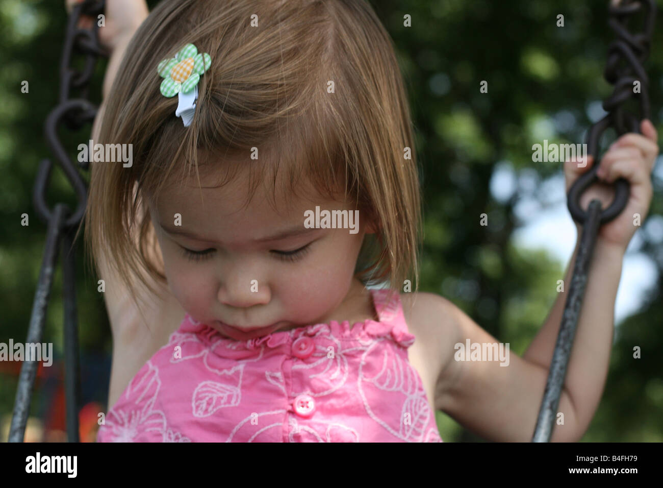 A 21 Mois Bebe Fille Regarde Vers Le Bas Alors Qu Il Etait Assis Dans Un Seau De Swing Photo Stock Alamy