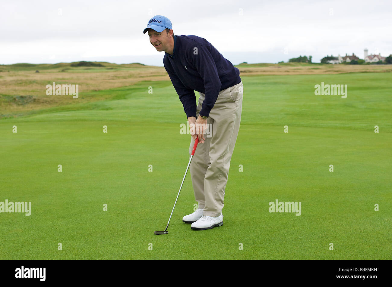 Golfeur professionnel alignement d'un putt sur le green (partie d'une série) Banque D'Images