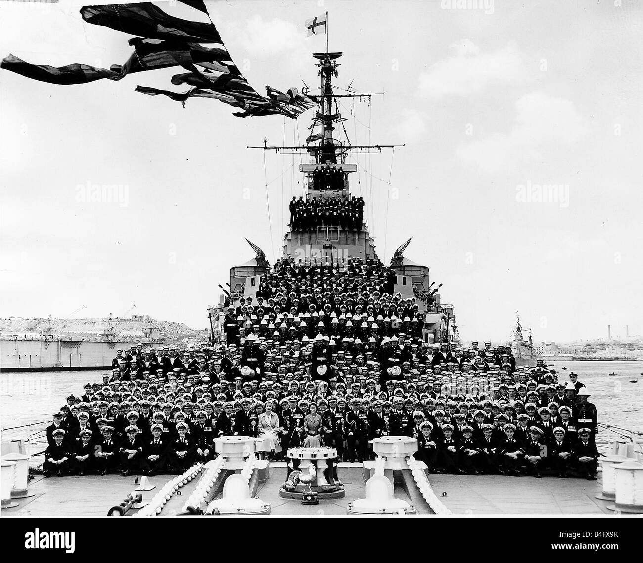 Lord Mountbatten pose pour une photo avec la reine Elizabeth et le prince Philip à l'équipage des navires sur le pont principal du HMS Glasgow Mai 1954 Banque D'Images