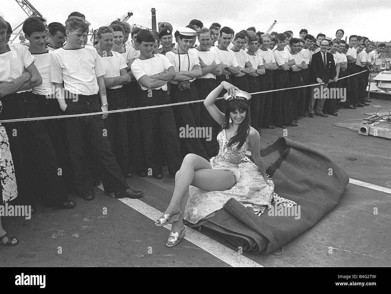 L'Albion Juillet 1967 L'une des filles de l'Billy Smarts Circus se trouve sur le pont d'envol du porte-avions portant l'un des marins caps lors d'une performance pour l'équipage Banque D'Images