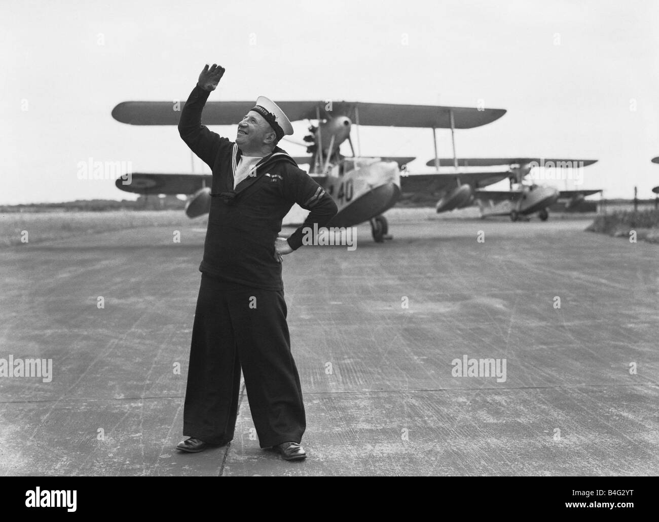 Fleet Air Arm Royan Naval Air Station Lee le Solent un technicien qui pose pour la caméra regarde vers le ciel pour les avions hydravions Supermarine Walrus à Paphos Banque D'Images