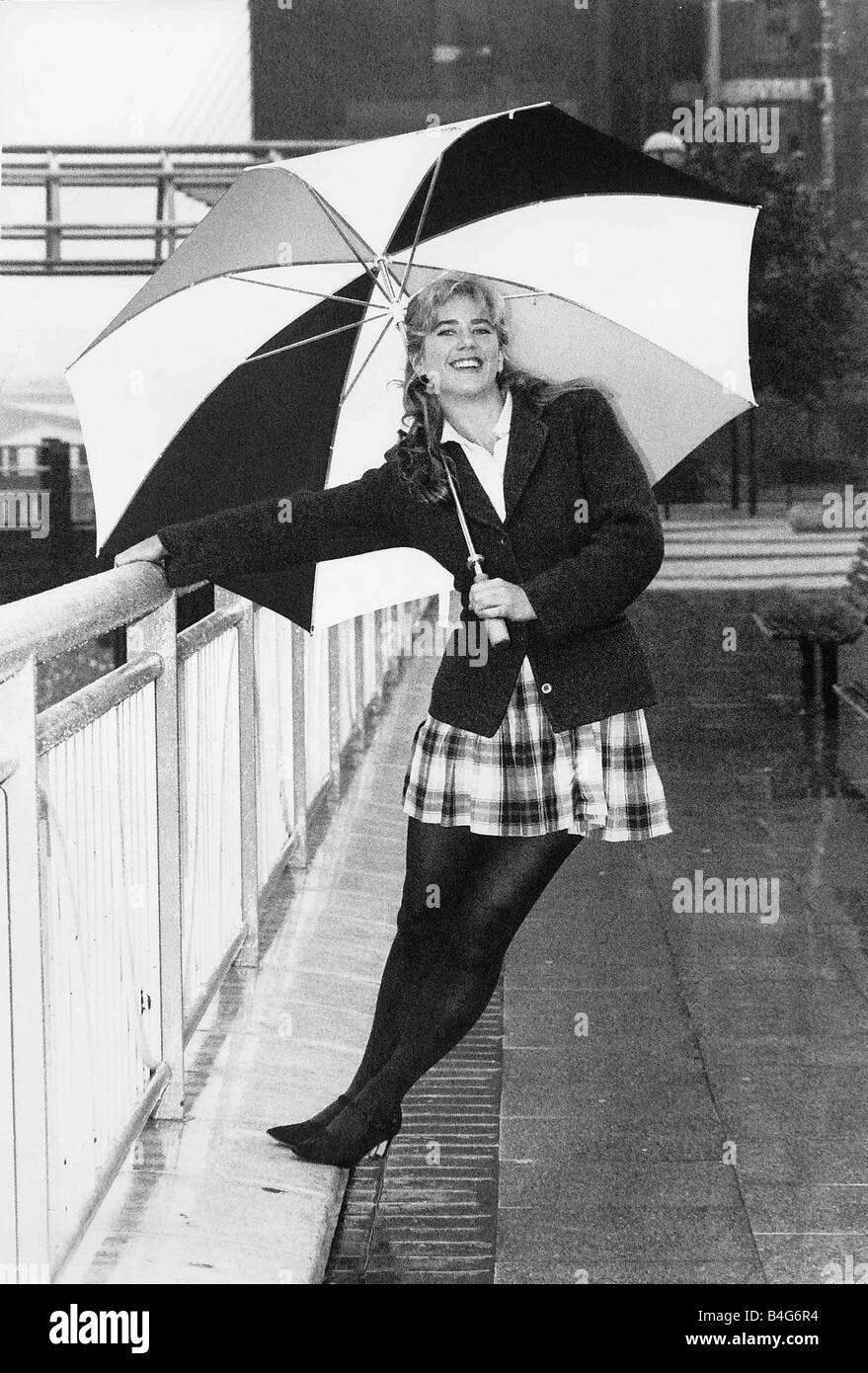 L'actrice Imogen Stubbs holding up parapluie et se pencher en arrière tout en maintenant railing Banque D'Images