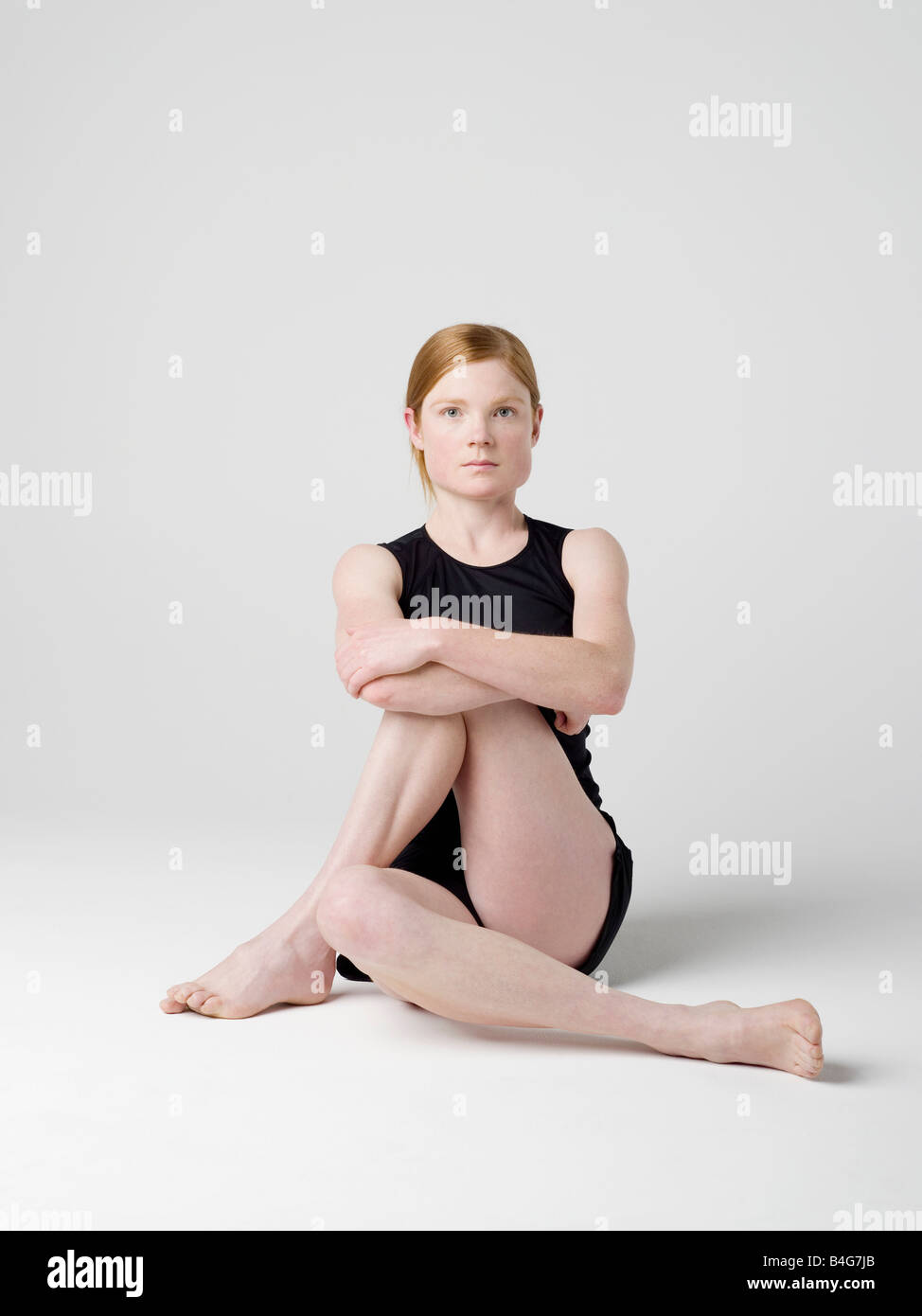 Une jeune femme début les' Moelle Twist' yoga pose Banque D'Images