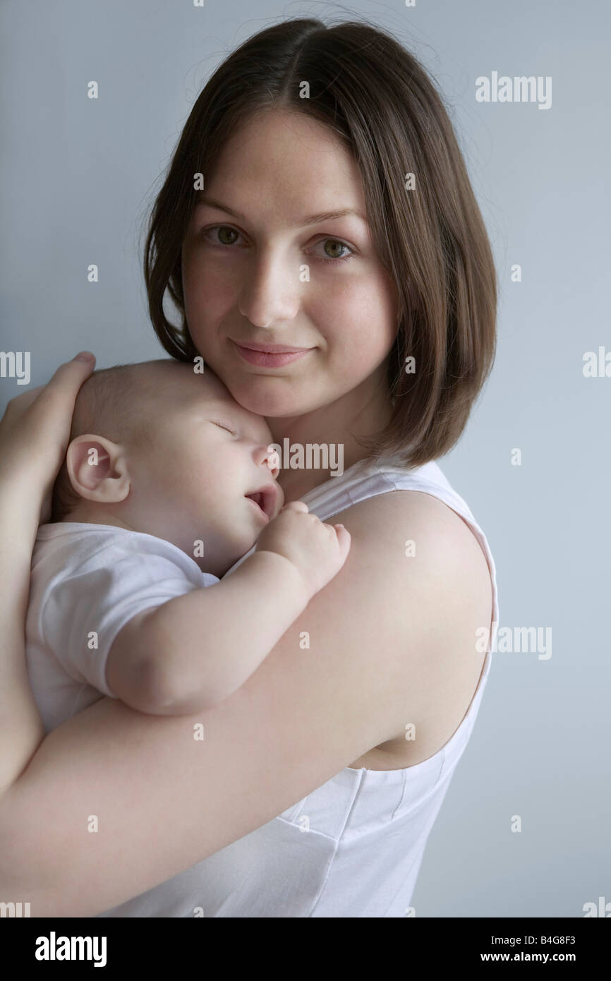 Une mère tenant un bébé endormi Banque D'Images