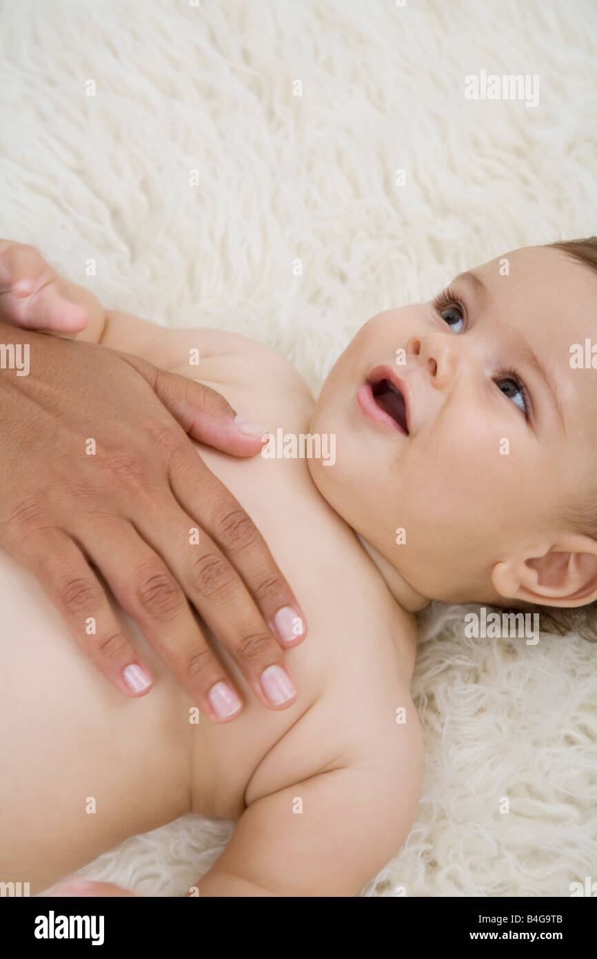 Une main humaine réconforter un bébé Banque D'Images