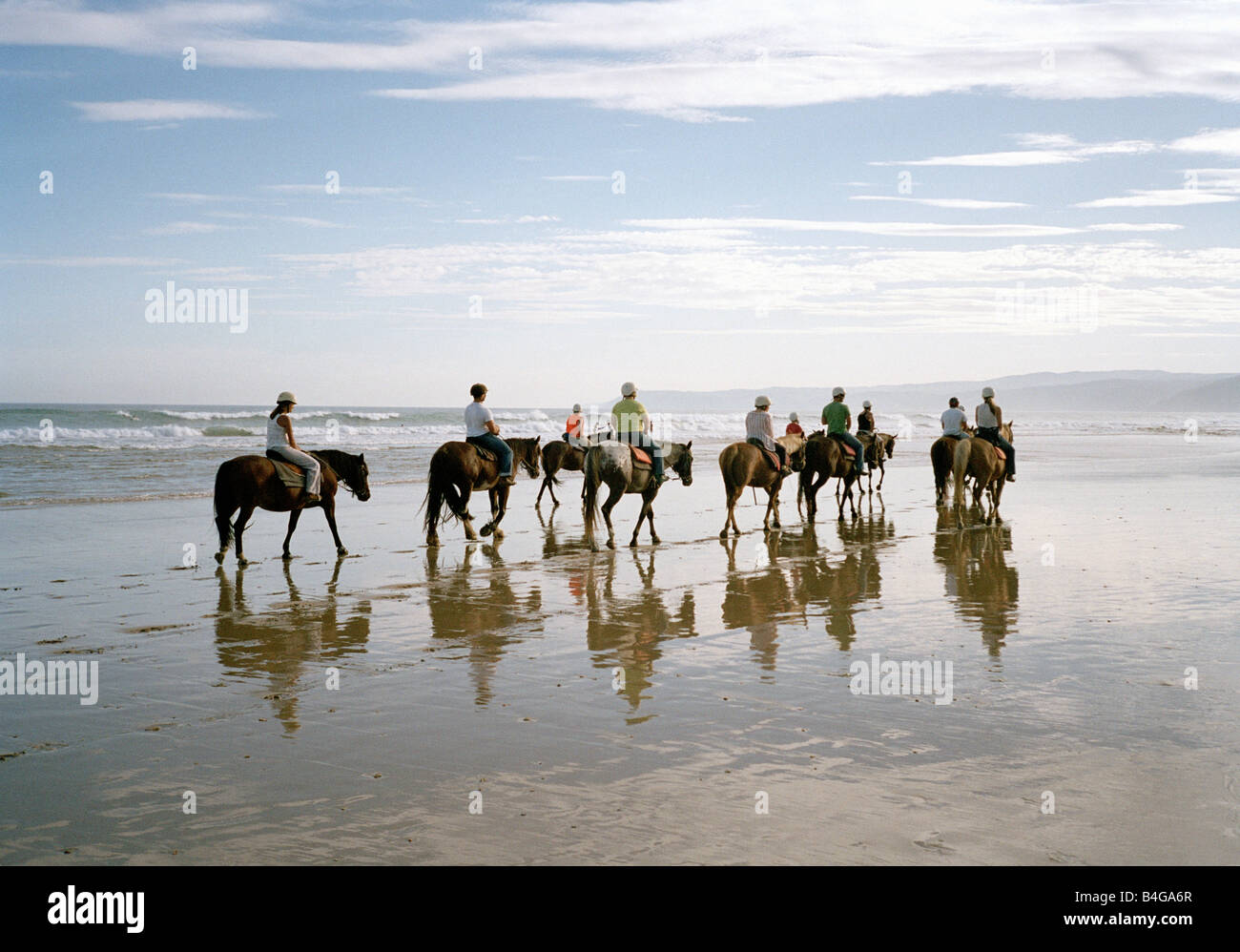 Un groupe de personnes l'équitation sur une plage Banque D'Images