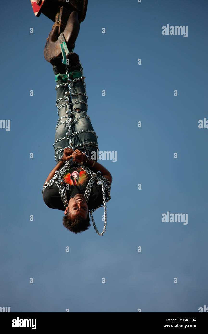 Akash Jadugar enchaînés entièrement suspendu dans l'air avec l'aide d'une grue en prélude à une sortie de secours show à Trivandrum, Kerala, Banque D'Images