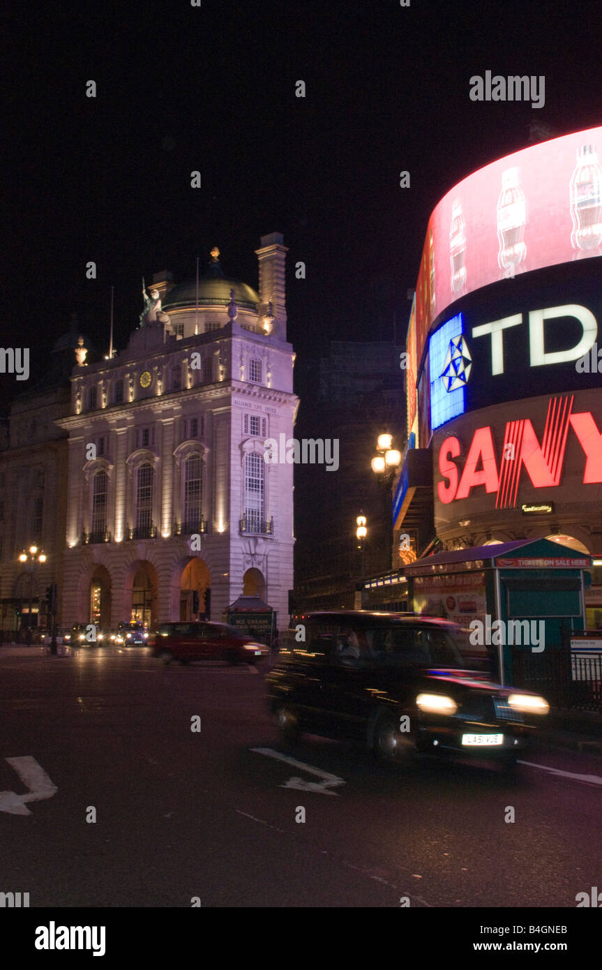 Taxi noir brouillée par les lecteurs de Piccadilly en vertu de la publicité au néon de nuit à Londres Banque D'Images