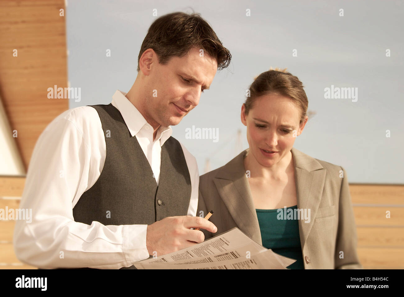 Close-up of two businesspeople looking at documents sur terrasse Banque D'Images