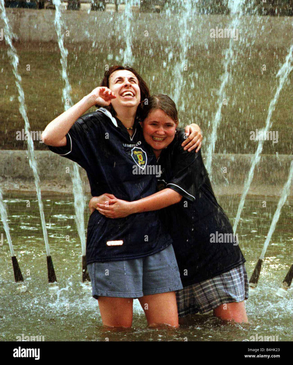 France Coupe du Monde 1998 femmes membres de l'armée de tartan Marianne Madill et Heather Pringle dans une fontaine à Saint Etienne Banque D'Images