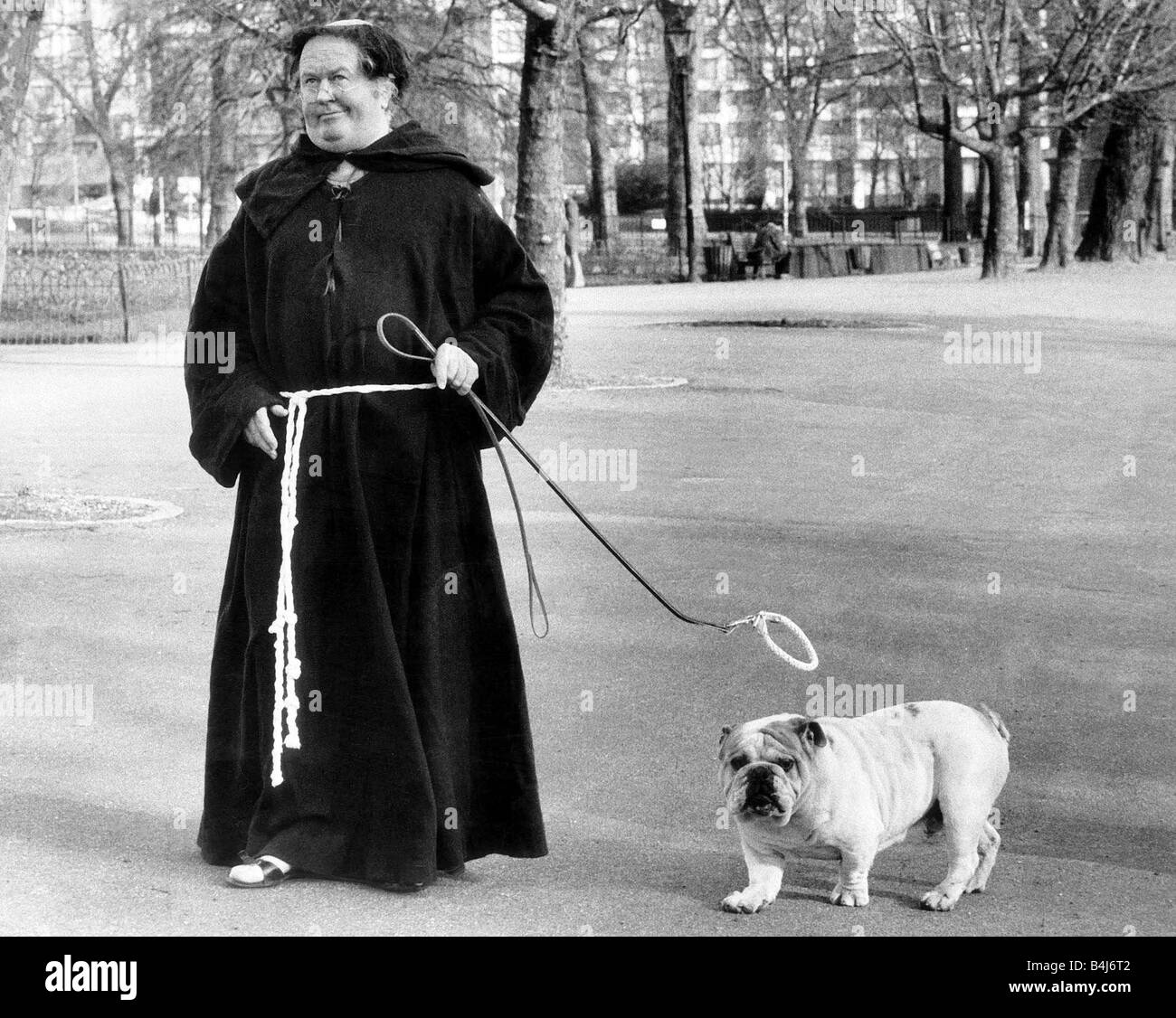 Simon le Bulldog un peu saint avec son halo doré au-dessus de sa tête avec son maître vêtu comme un moine dans Hyde Park Londres Banque D'Images Simon le Bulldog un peu saint avec son halo doré au-dessus de sa tête avec son maître vêtu comme un moine dans Hyde Park Londres Banque D'Images