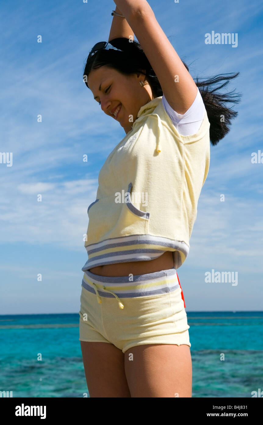 Jeune femme brune en tenue de sport sur la plage Banque D'Images