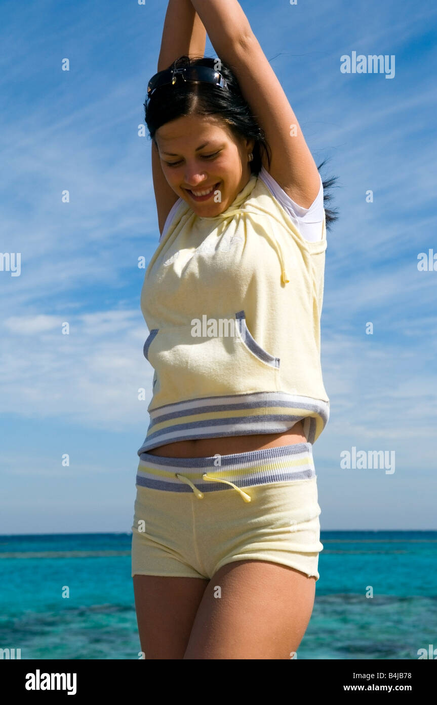 Jeune femme brune en tenue de sport sur la plage Banque D'Images