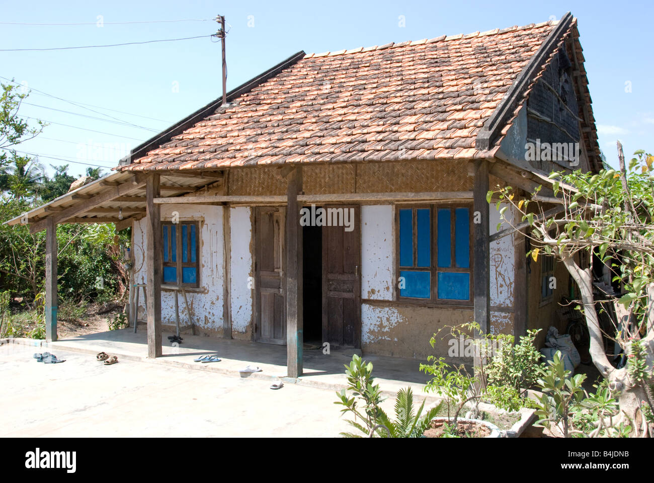 Maison à la campagne vietnamienne avec murs de plâtre blanc et rouge à carreaux près de Phan Thiet Vietnam Banque D'Images
