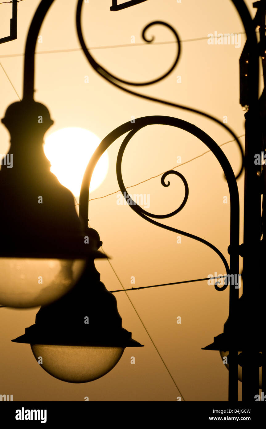 Soleil qui brille à travers les aux éléments en fer forgé de la lampe posts de Marina della Lobra Banque D'Images