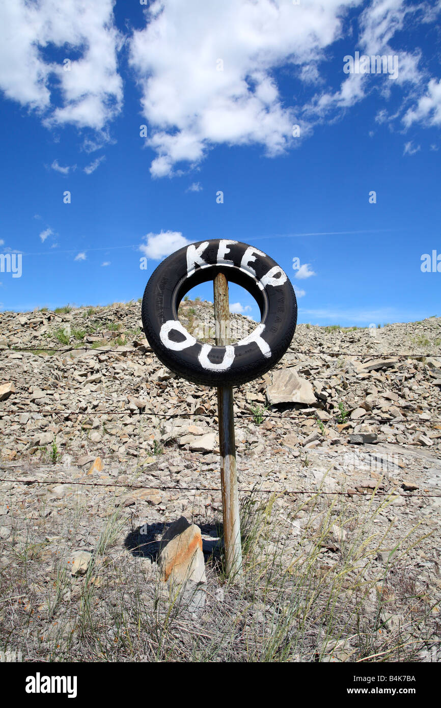 Barbelés avec pneus sign painted garder hors près de Pincher Creek, Alberta, Canada Banque D'Images
