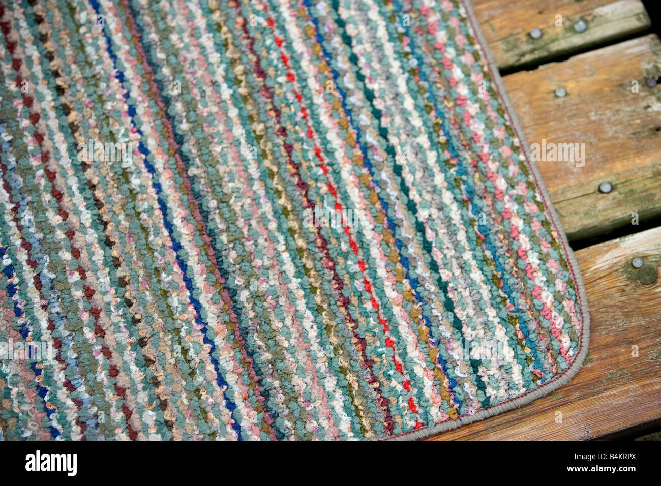 Un petit tapis jeter sur une terrasse en bois. Banque D'Images