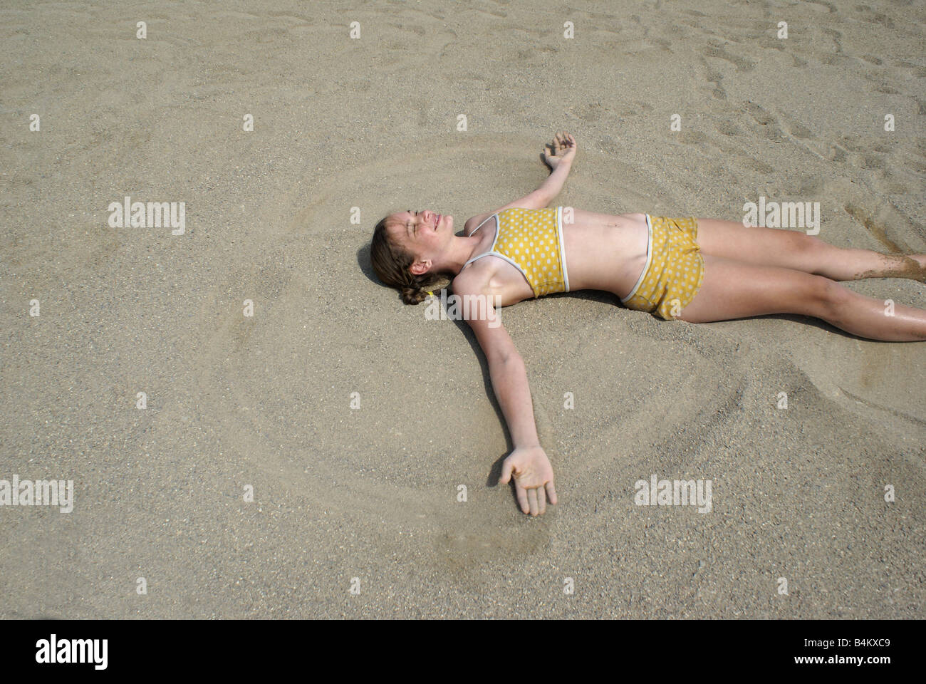 Caucasian child yellow swimsuit lay in sand moving arms eyes closed facing  upward legs spread spread Banque de photographies et d'images à haute  résolution - Alamy