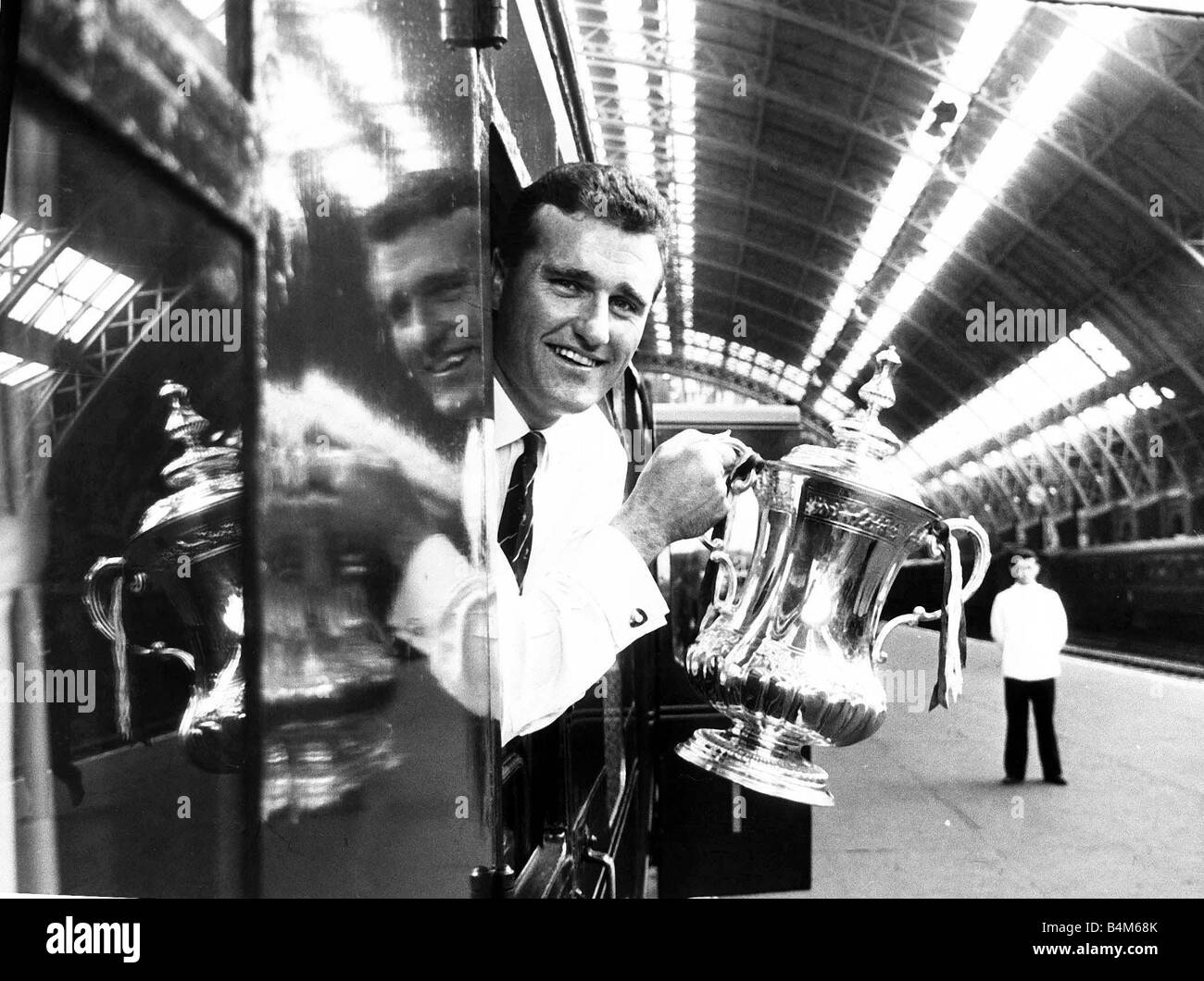 Le capitaine de Manchester United Noel Cantwell s'appuyant de la avec la FA Cup trophy à Saint Pancras station sur le chemin de retour à Manchester Mai 1963 Banque D'Images