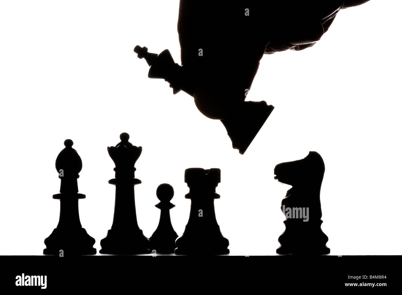 Main mâle déménagement pièces des échecs silhouetté sur chess board Banque D'Images