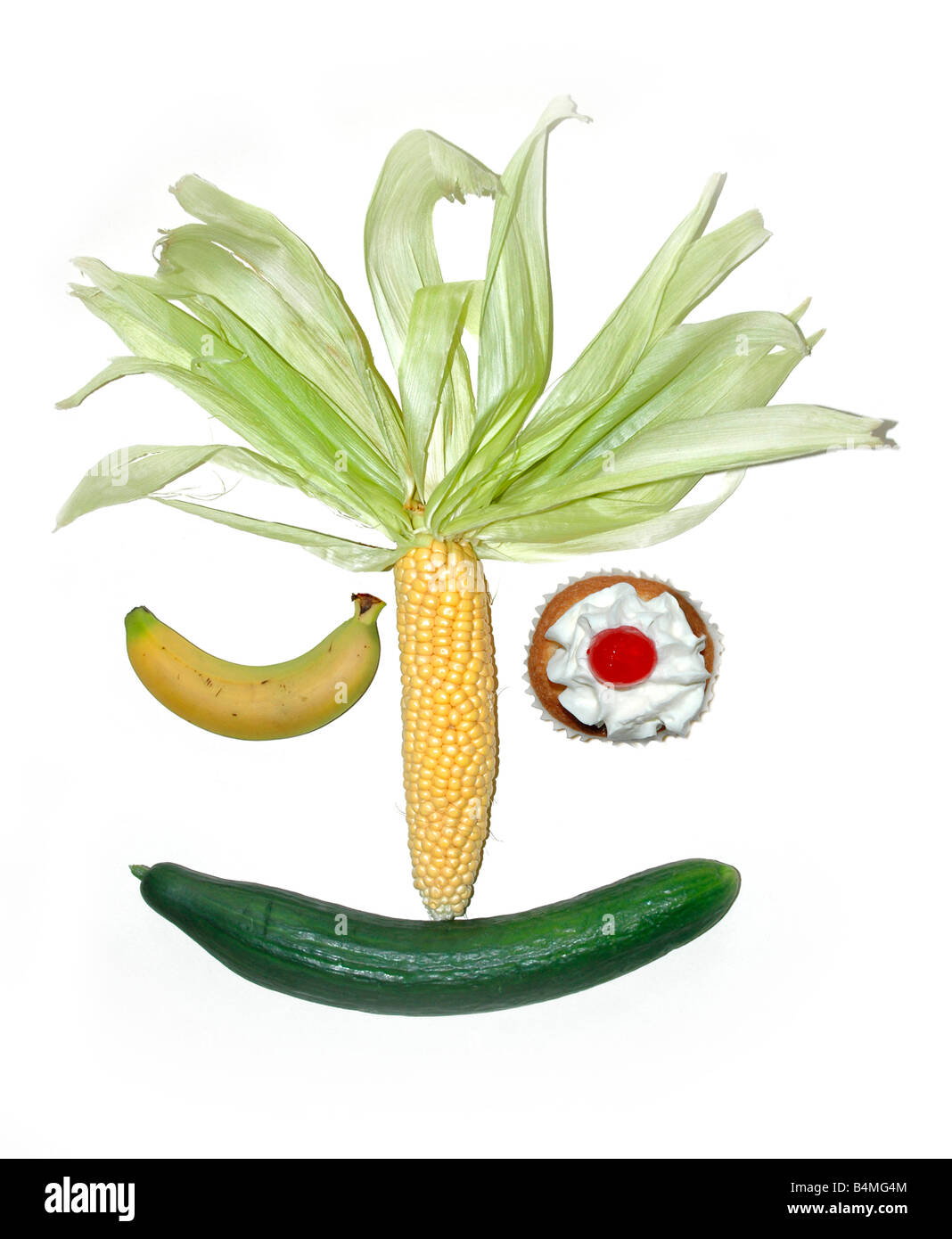 Un visage souriant et clignant composé avec une variété de fruits et légumes à l'exception de l'oeil ouvert qui dépeint un gâteau à la crème. Banque D'Images