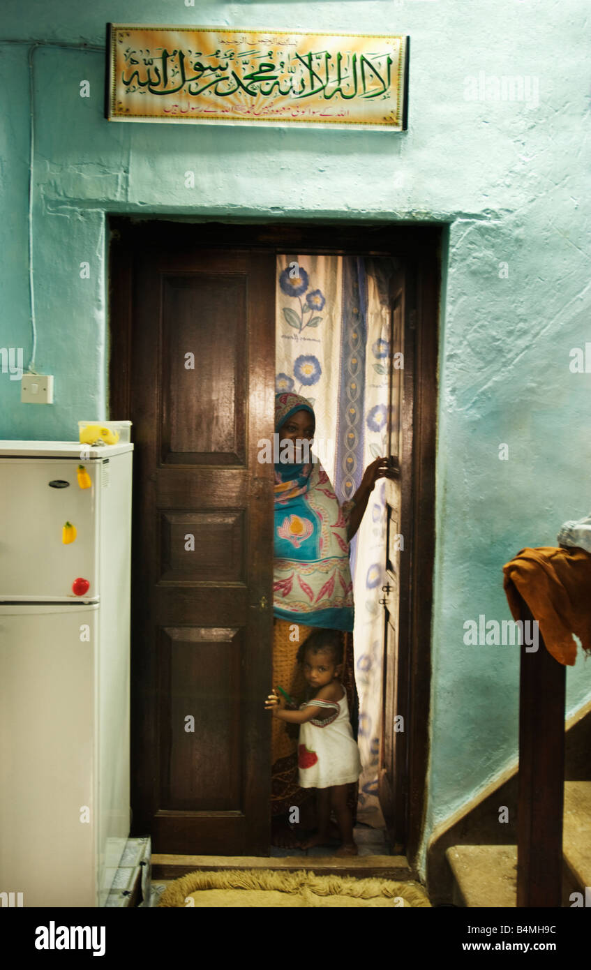 La mère et l'enfant en porte d'habitation à Stone Town Zanzibar Tanzanie Afrique l'escalier mène aux étages supplémentaires Banque D'Images