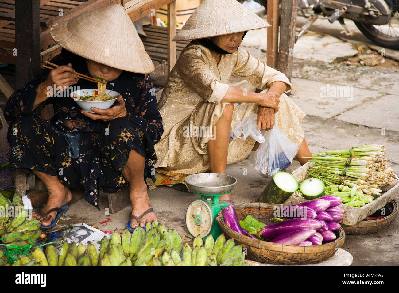 Les femmes de chapeaux coniques traditionnels dans le marché de la vieille ville de Hoi An, Vietnam ; Banque D'Images