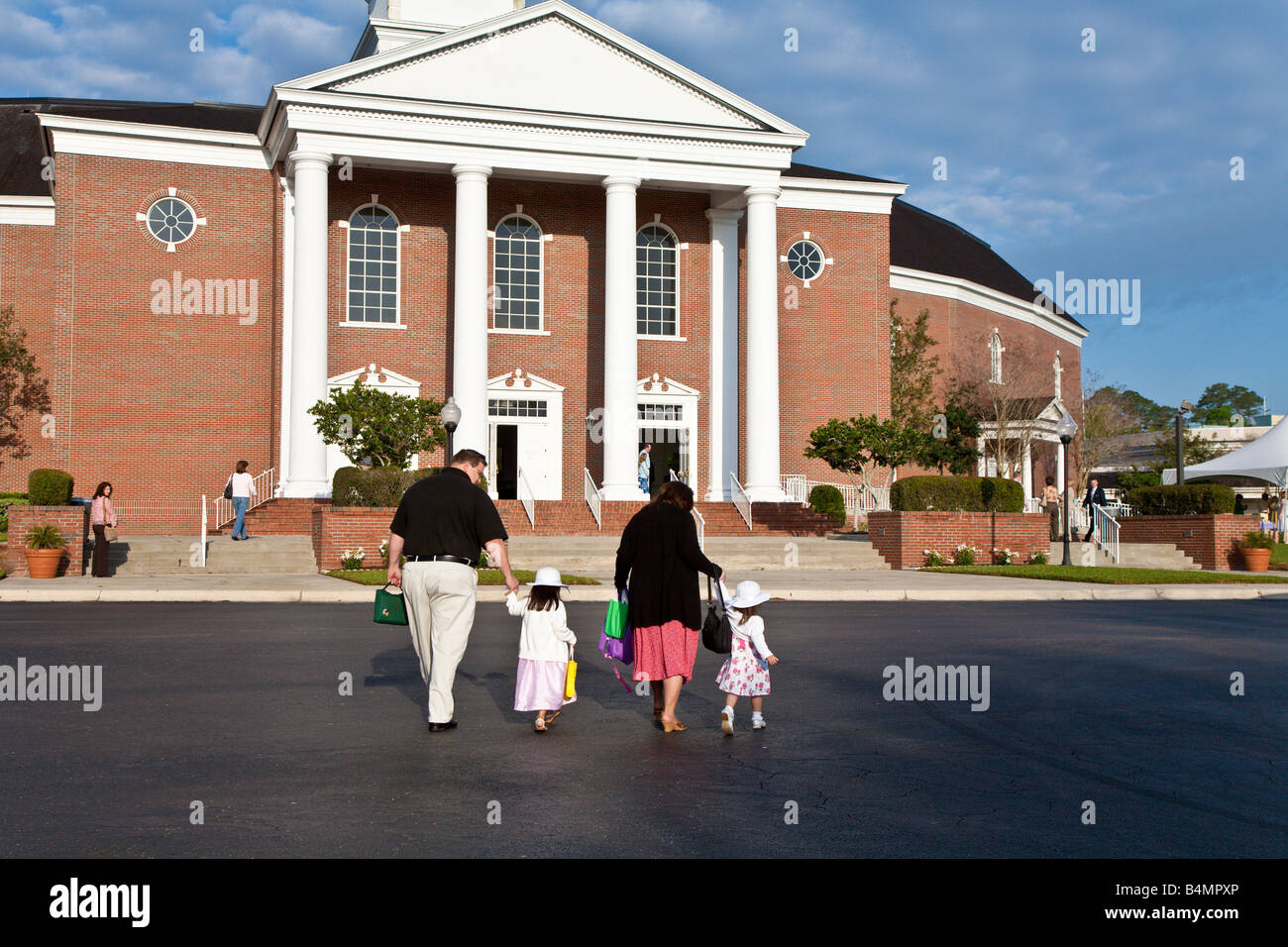 Famille de quatre personnes qui vont à l'église le dimanche matin Banque D'Images