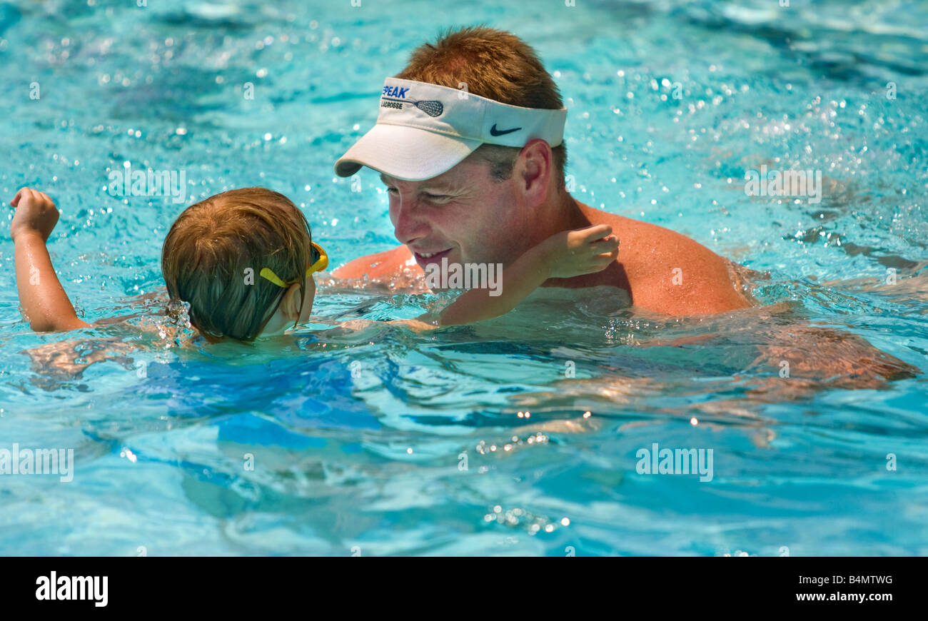 Un père et sa fille swimming in pool d'histoires sur la sécurité des piscines. La piscine dispose d'un robinet d'arrêt si les enfants filtres tactile Banque D'Images