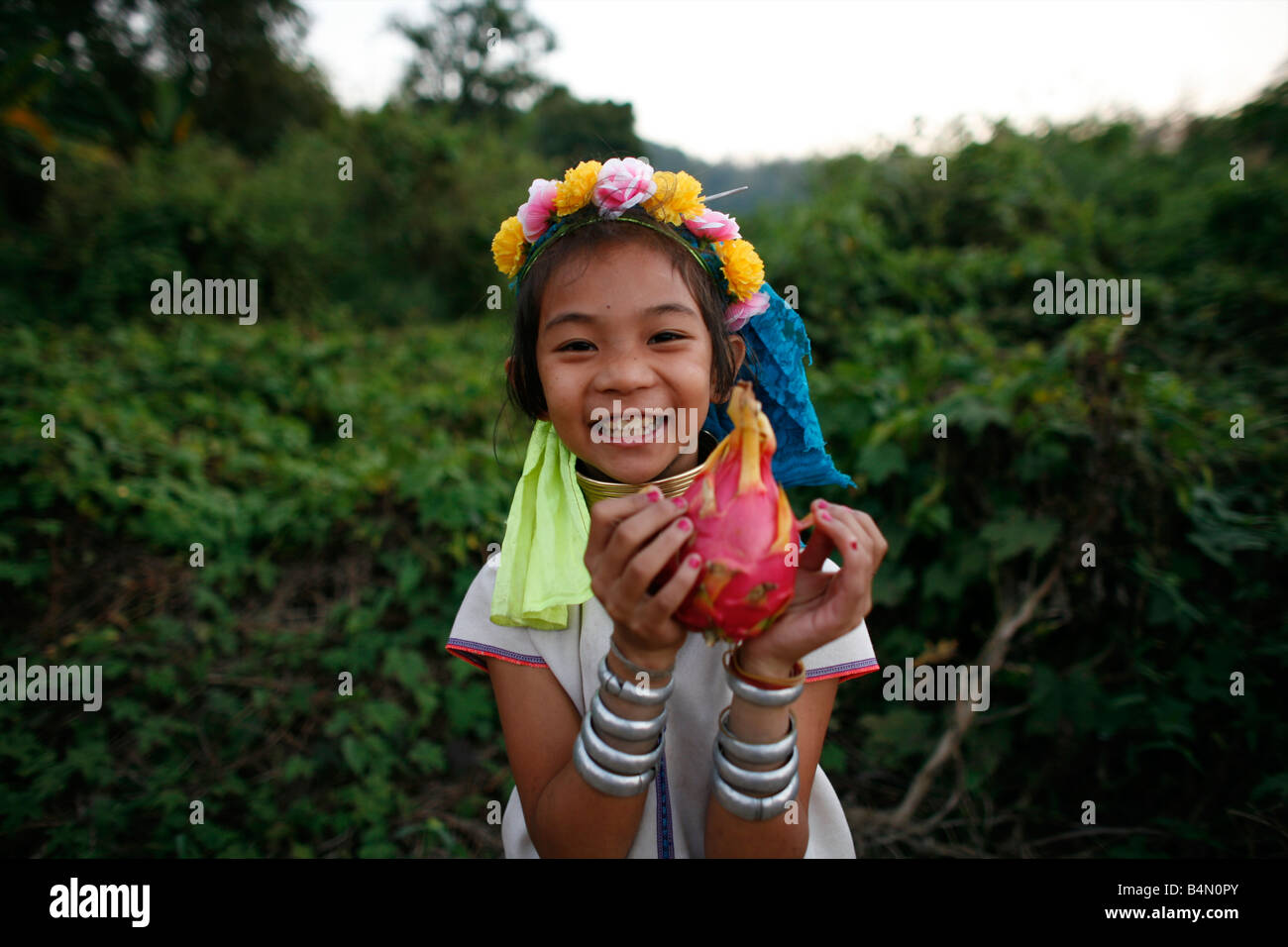 Baidjan Laughing girl holding fruit approximativement 300 réfugiés birmans en Thaïlande sont membres de communautés indigènes Longnecks groupe connu sous le nom de la plus grande des trois villages où l'Longnecks live est appelé Nai Soi situé près de la ville de Mae Hong Son Longnecks porter des bagues métalliques sur le cou qui poussent la clavicule et étendre le cou Ils sont une attraction touristique touristes visitent Nai Soi pour prendre des photos de l'Longnecks et acheter leur artisanat Les villages sont critiqués par les organisations des droits de l'homme comme les zoos Banque D'Images