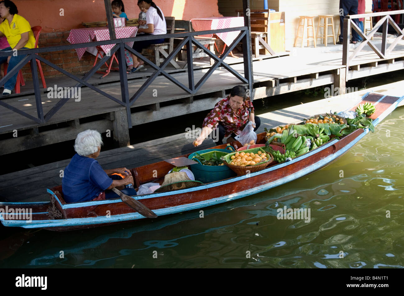 Une vieille femme vendeur de fruits par bateau au marché flottant de Taling Chan Banque D'Images