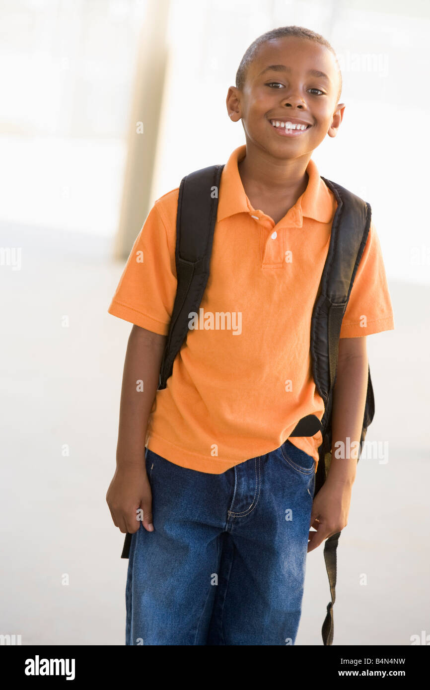 Student standing outdoors smiling (high key) Banque D'Images