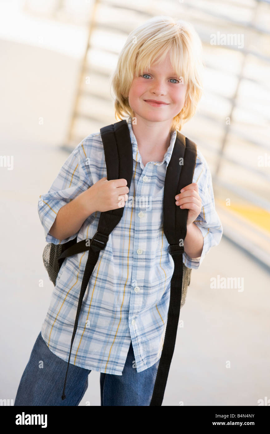 Student standing outdoors smiling (high key) Banque D'Images