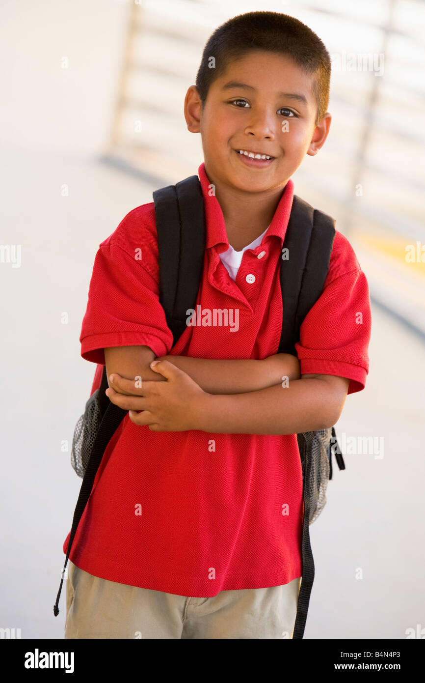 Student standing outdoors smiling (high key) Banque D'Images
