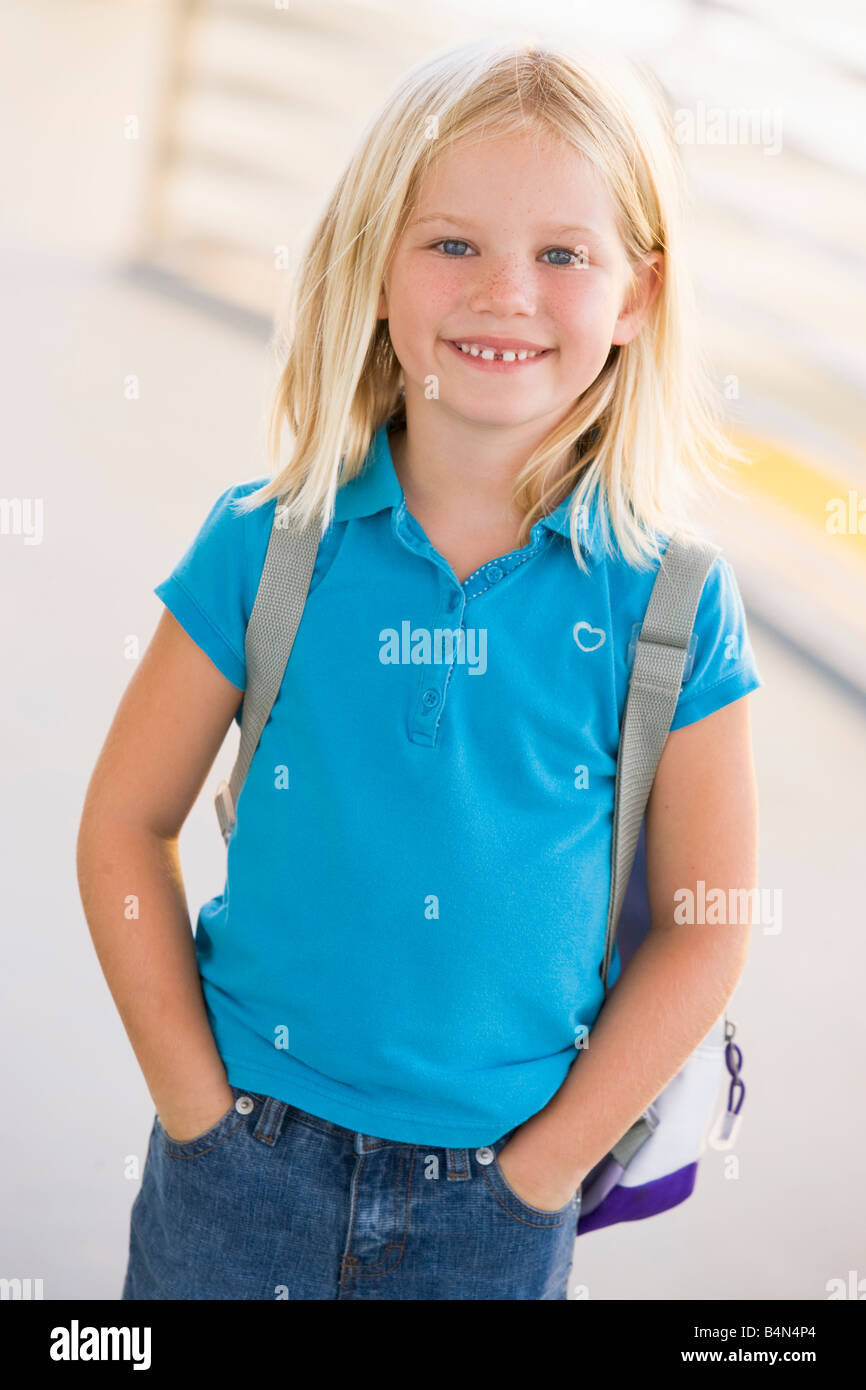 Student standing outdoors smiling (high key) Banque D'Images