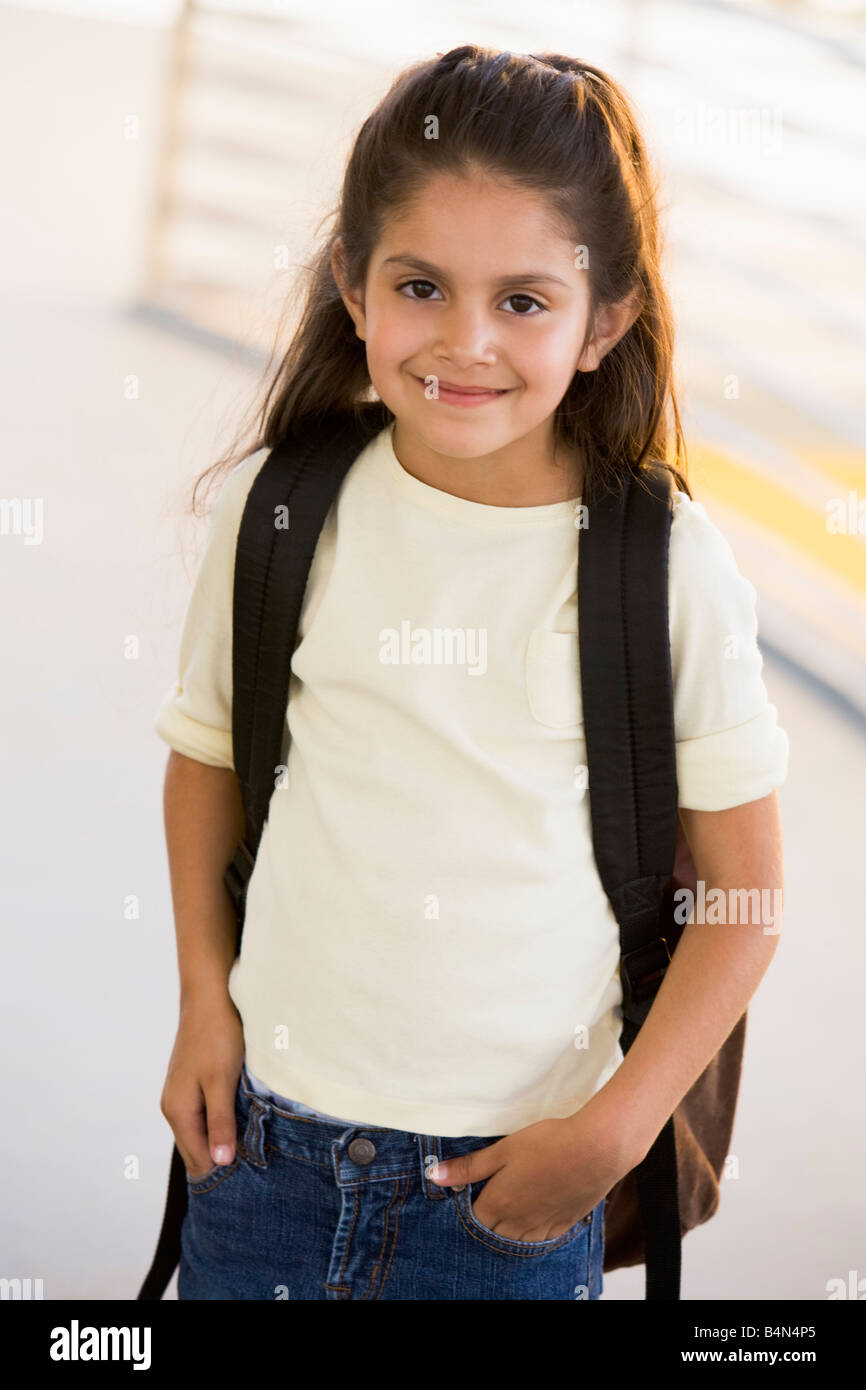 Student standing outdoors smiling (high key) Banque D'Images