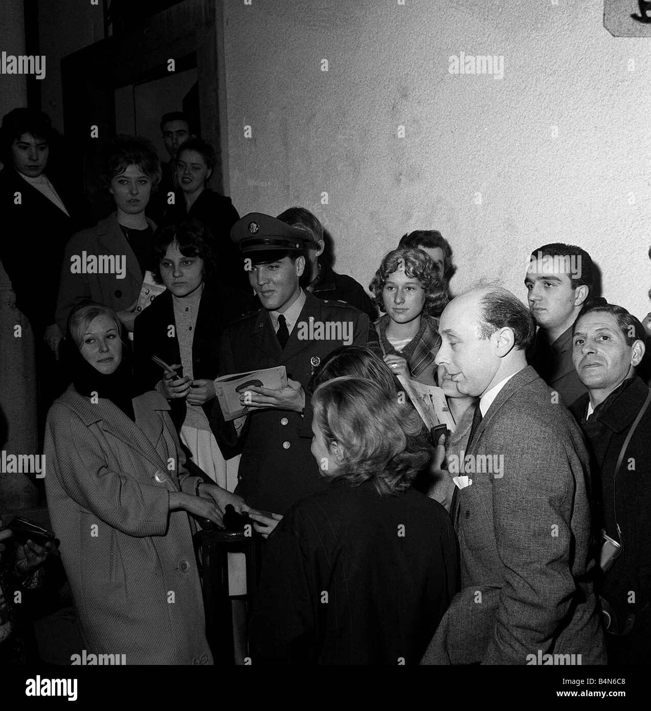 Elvis Presley avec les fans lors d'une conférence de presse en Allemagne 1960 Bernard Clavel écrivain miroir en premier plan Banque D'Images