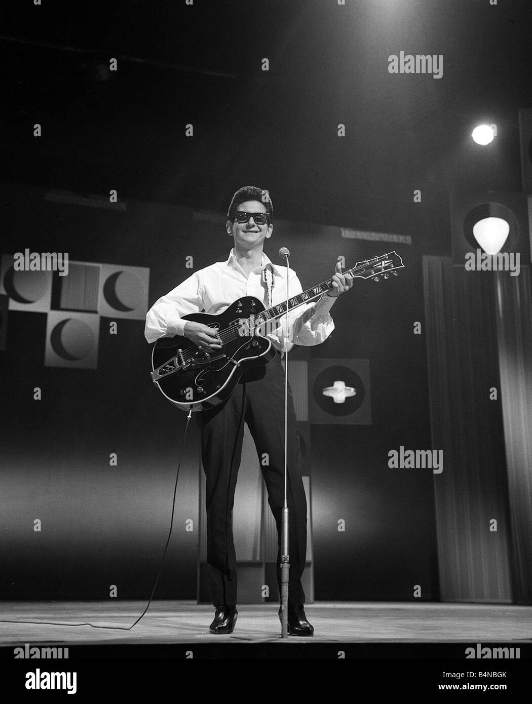 Roy Orbison chanteur pop Mars 1965 effectuant le dimanche soir au London  Palladium en jouant de la guitare de lunettes noires Photo Stock - Alamy